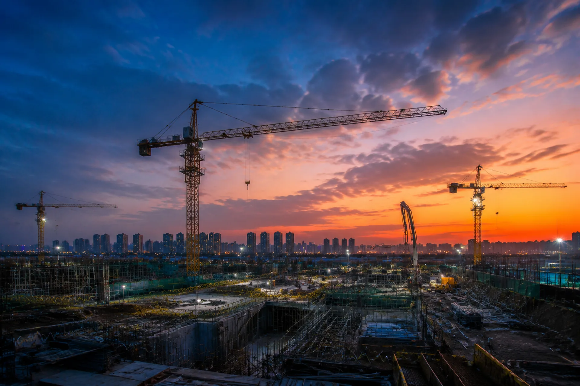 Tower cranes on a construction site at dusk